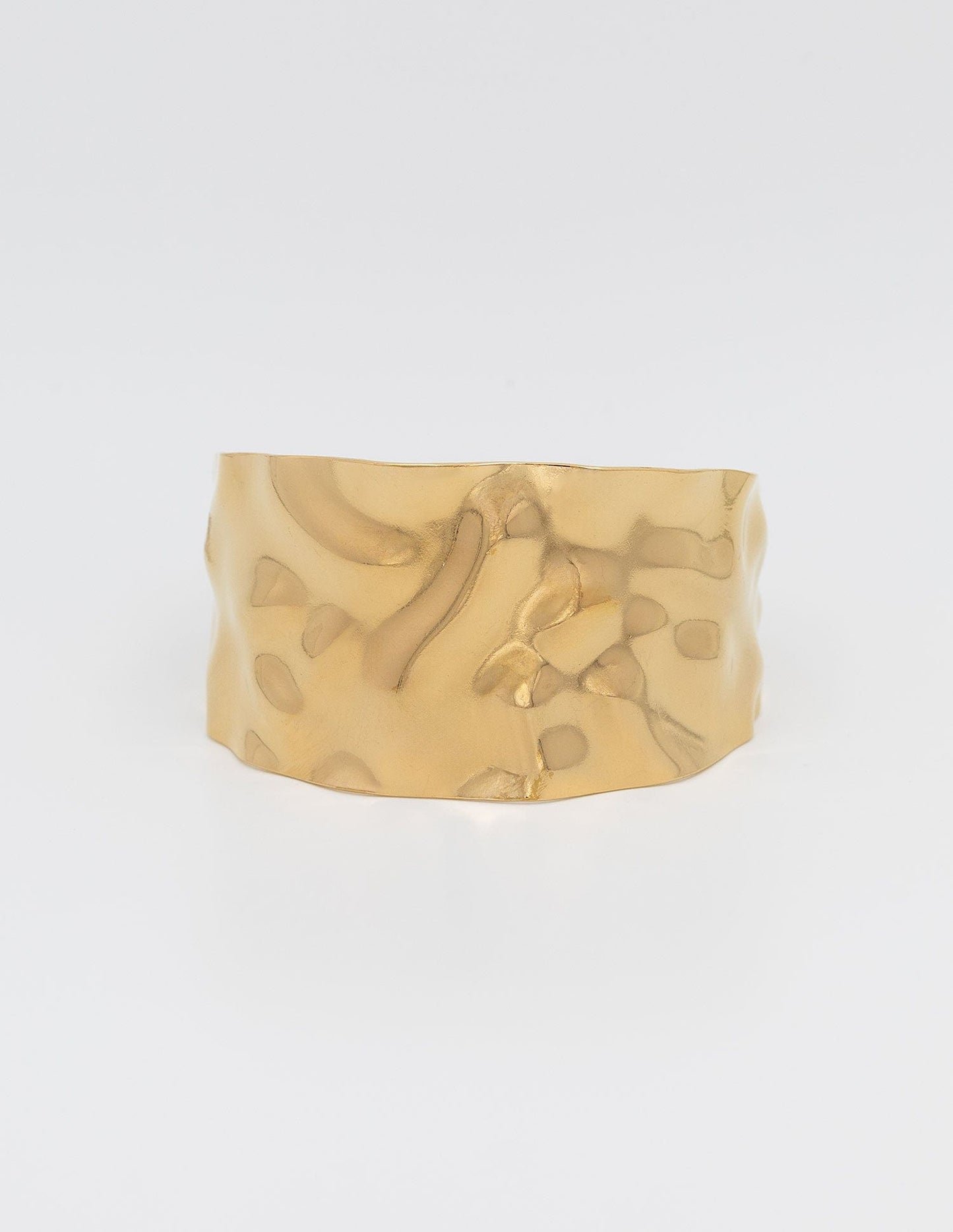pulsera ancha dorada rígida con textura ondulada