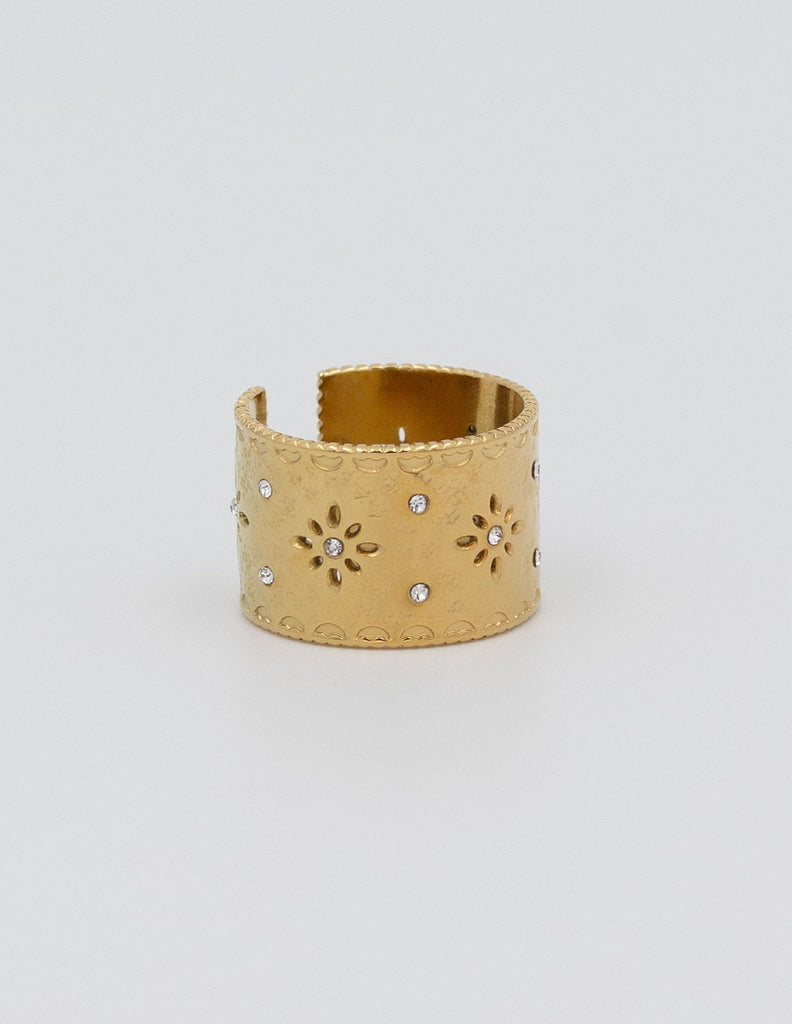anillo ancho dorado con flores caladas y circonitas pequeñas con un borde irregular