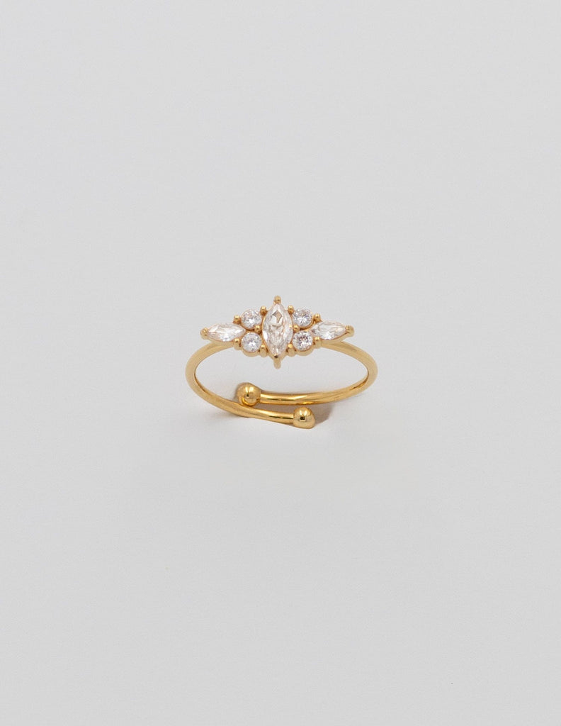 anillo fino de color dorado con una circonitas centras y tres de cada lado con diferentes formas