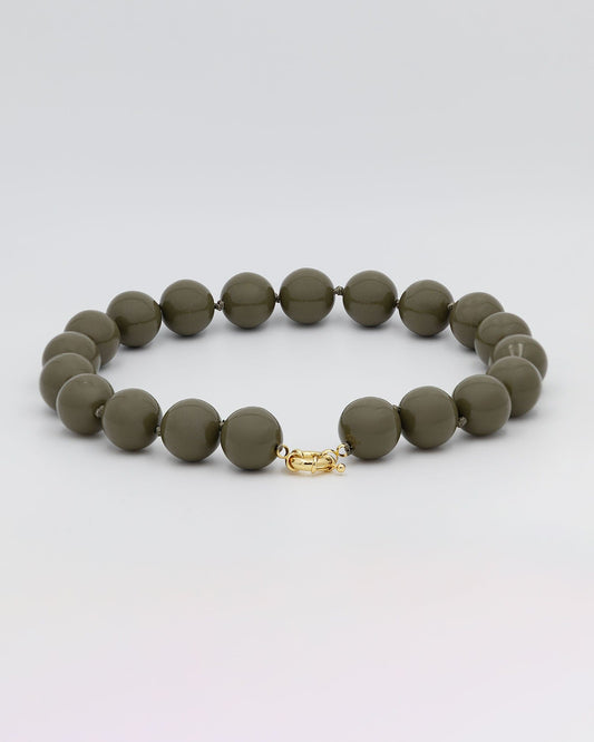 un collar de bolas de resina en color caqui con cierre en acero dorado