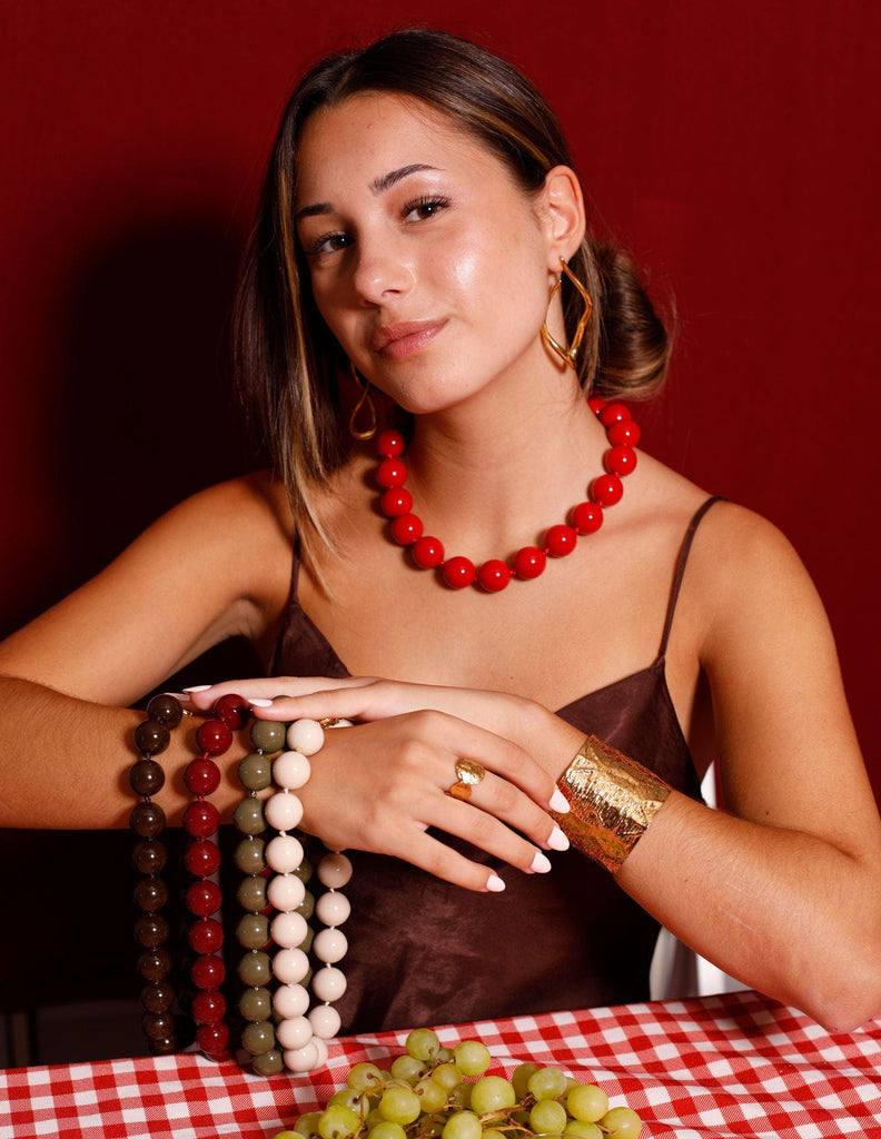 CHICA CON COLLAR BOLAS ROJO Y COLLARES COLORES EN EL BRAZO
