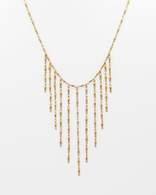un collar tipo chócker en acero dorado que le cuelgan tiras dorados tipo flecos