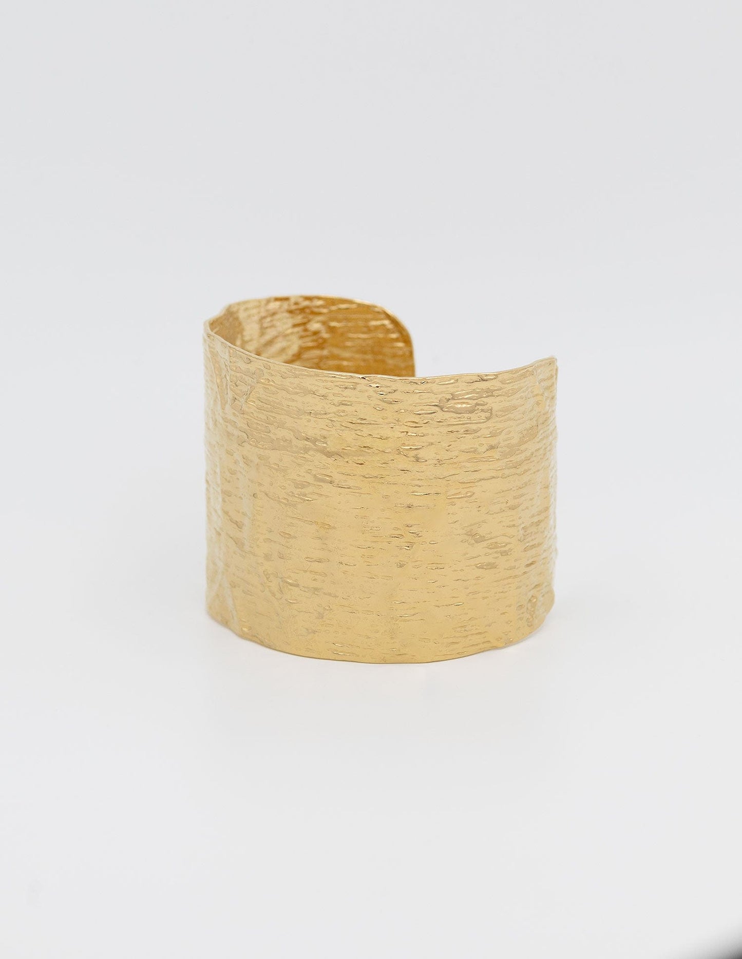 pulsera rigida ancha dorada con textura rugosa