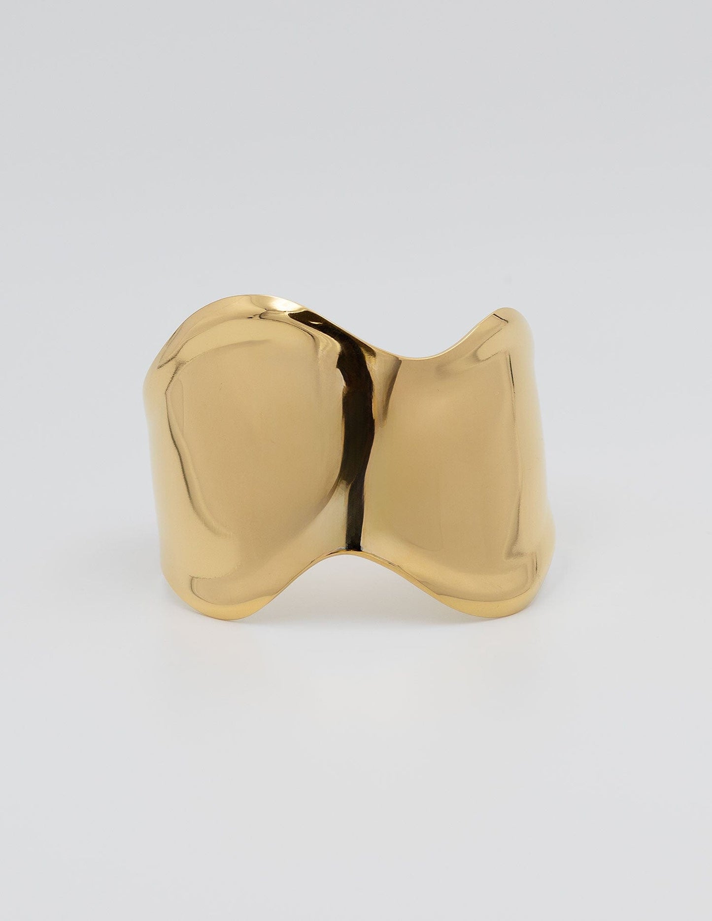 esclava rígida dorada brillante con forma ondulada