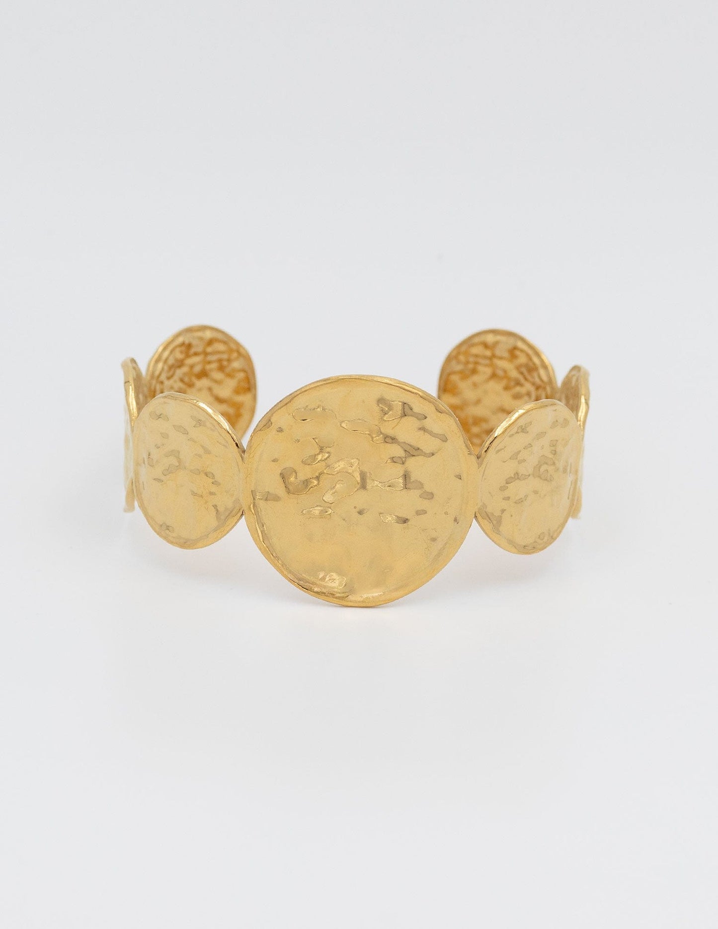 pulsera rigida de medallas tres pequeñas de cada lado en el centro una más grande