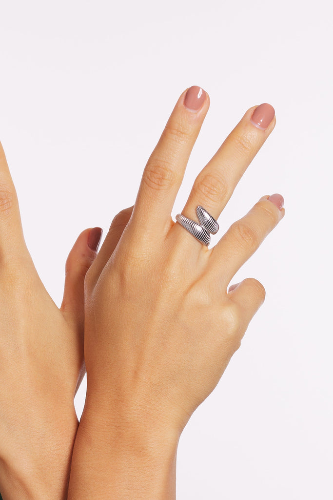 anillo plateado doble en el dedo con detalles de rayas